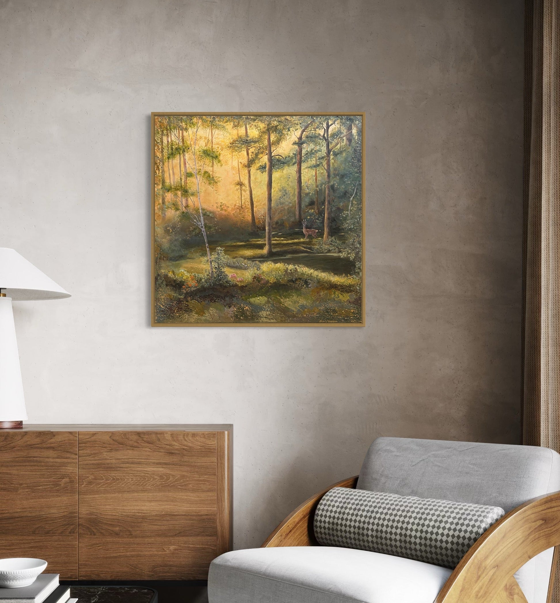 Framed landscape painting on a wall above a wooden cabinet and chair.
