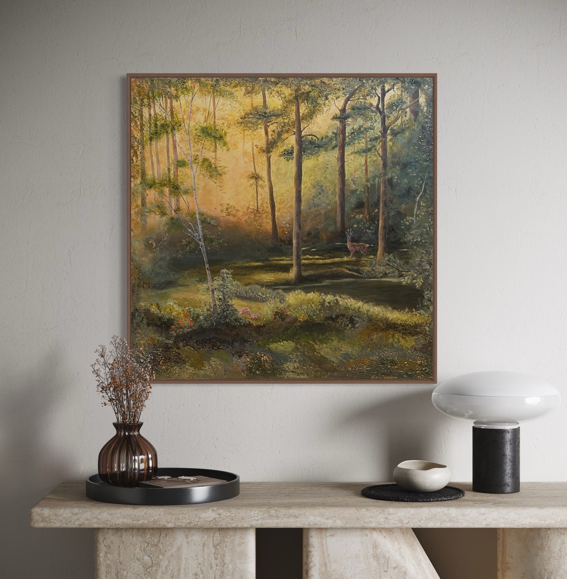 Framed landscape painting on a wall above a console table with decorative items.