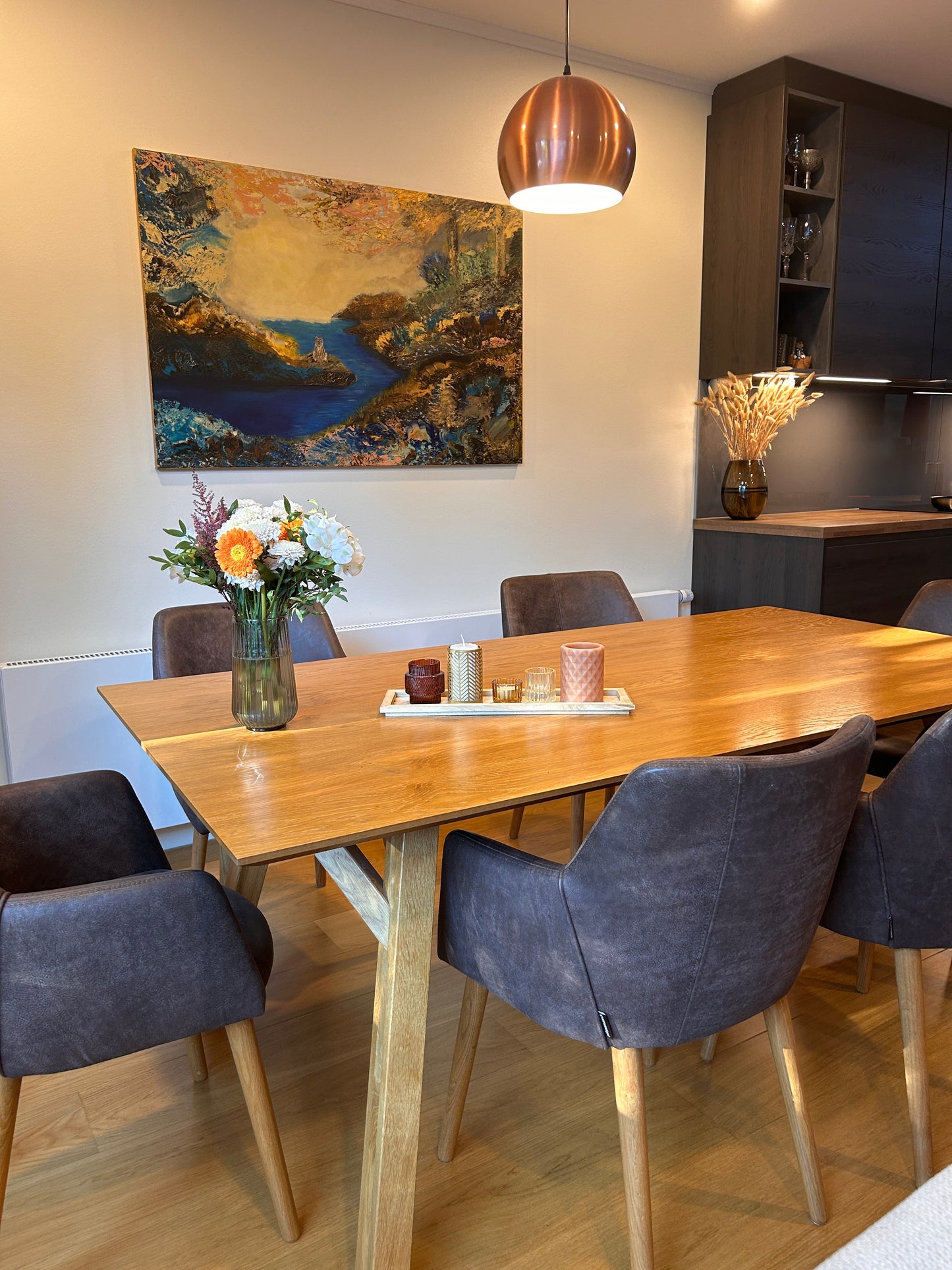Dining area with wooden table, chairs, and decorative elements.